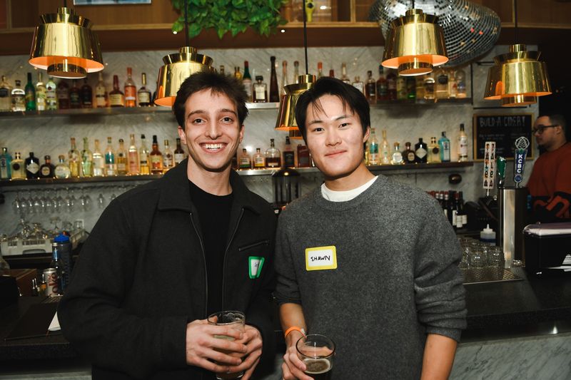 Two guests with drinks in front of the bar